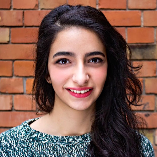 Photo of Ferdous outside, she is smiling and wearing red lipstick