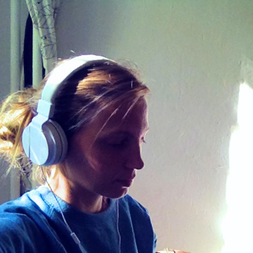 Photo of Kaja, a 3/4th angle, wearing headphones with a blue top